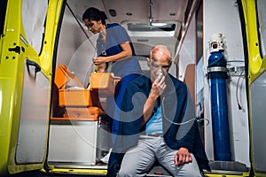 Ambulance car, a young nurse is checking her medical kit to provide the first aid to her patient