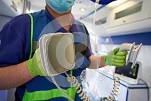 Ambulance doctor with defibrillator electrodes in his hands