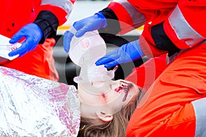 Ambulance doctor giving oxygen to female victim