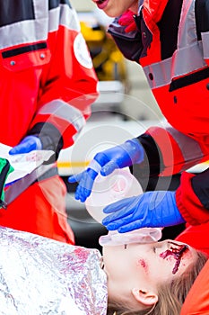 Ambulance doctor giving oxygen to female victim
