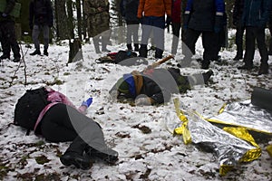 Ambulance drills in the winter forest. Several allegedly drunk people lie with knives and axes in their backs and resist