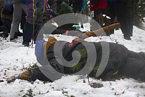 Ambulance drills in the winter forest. A supposedly drunk man with an ax in his back lies on the ground and resists