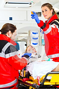 Ambulance helping injured woman with infusion