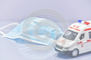 Ambulance model with medical mask on white background