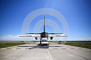An ambulance is parked near the rear exit of an Alenia C-27J Spartan military cargo plane from the Bulgarian Air Force that