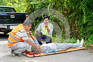 Ambulance and rescue workers helping woman driver from car accident on road