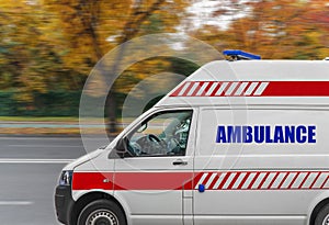 Ambulance service van driving fast on street