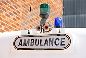 Ambulance sign with blue and green flashing lights.