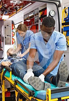 Ambulance team laying patient on stretcher