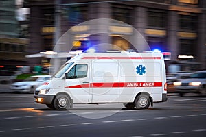 Ambulance Van on a wide city street. White emergency vehicle with warning lights and siren moving fast an avenue