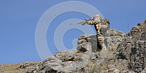 Ambush in the mountains - special forces professional sniper aiming at the enemy in the mountains.