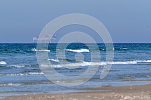 Ameland,Netherlands April 20,2021-NAM, Oil rig, offshore platform with beach, sand and surf. Natural gas extraction in