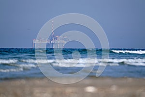 Ameland,Netherlands April 20,2021-NAM, Oil rig, offshore platform with beach, sand and surf. Natural gas extraction in