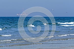 Ameland,Netherlands April 20,2021-NAM, Oil rig, offshore platform with beach, sand and surf. Natural gas extraction in