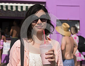 Amerasian teenager in the sun with a milkshake