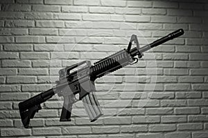 American army rifle M4A1 against a brick wall