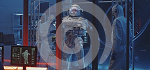 American astronaut testing spacesuit mobility