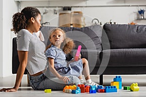 American babysitter and girl looking at