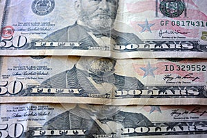 American banknotes in the amount of fifty 50 US dollars located on a wooden background.