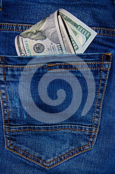 American banknotes in jeans pocket. A note in denominations of $ 100 peeps, stick out from the back, the foremost pants pocket.