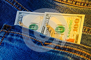 American banknotes in jeans pocket. A note in denominations of $ 100 peeps, stick out from the back, the foremost pants pocket.