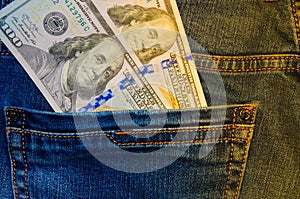 American banknotes in jeans pocket. A note in denominations of $ 100 peeps, stick out from the back, the foremost pants pocket.