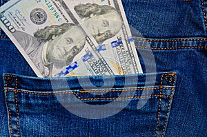 American banknotes in jeans pocket. A note in denominations of $ 100 peeps, stick out from the back, the foremost pants pocket.