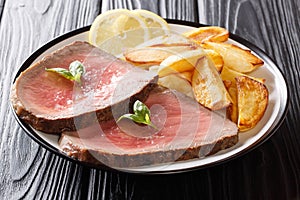 American beef steak with a fried potato slices close-up on a plate. horizontal