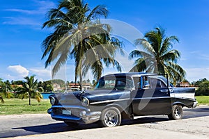 American black Chevrolet classic car parked under palms near the beach in Varadero Cuba - Serie Cuba Reportage