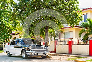 American black white 1956 vintage car parked in the sidestreet before a house in Varadero Cuba