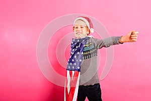 American boy celebrates Christmas with a big smile, isolated on background with American flag