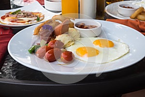 American breakfast with fried eggs, bacon, sausage and juice