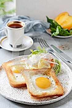 American breakfast on a plate with fried eggs in toast, with tomatoes, fresh daikon, carrots, arugula and espresso. Fried egg