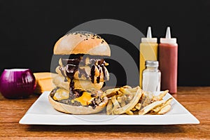 Doble burger with doble cheddar cheese, lettuce, bacon, mushrooms and french fries photo