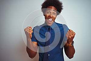 American business man with afro hair wearing blue shirt and tie over isolated white background celebrating surprised and amazed