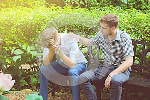 American businessmen consoling friend. Frustrated young man being consoled by his friend in garden. photo