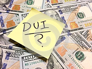 American cash money and yellow post it note with text DUI and question mark photo