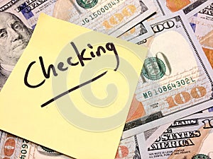 American cash money and yellow sticky note with text Checking photo