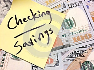 American cash money and yellow sticky note with text Checking and savings