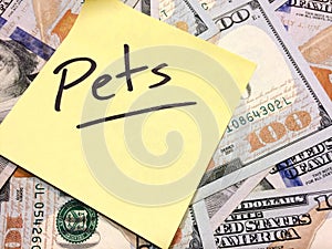 American cash money and yellow sticky note with text Pets photo