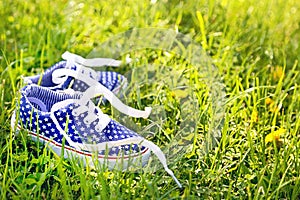 American children's sneakers on green grass background.