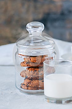 American chocolate chip cookies with glass of milk on a white st