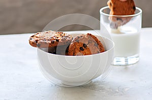 American chocolate chip cookies with glass of milk on a white st