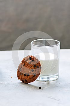 American chocolate chip cookies with glass of milk on a white st