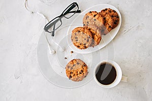 American chocolate chip cookies in a white plate cup of coffee