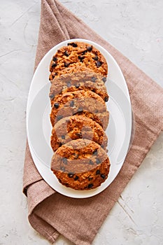 American chocolate chip cookies in a white plate on a white sto