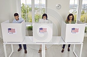 American citizens standing at vote center in voting booth at polling station on election day.