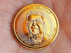 American coin lies on the palm. 1 dollar close up. Obverse coins featuring President Reagan. News about national currency, state