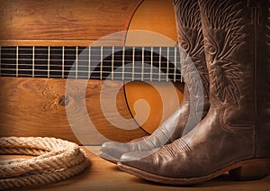 American Country music with guitar and cowboy shoes on wood text