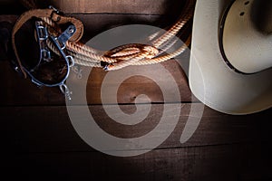 American Cowboy Items incluing a lasso spurs and a traditional straw hat on a wood plank background